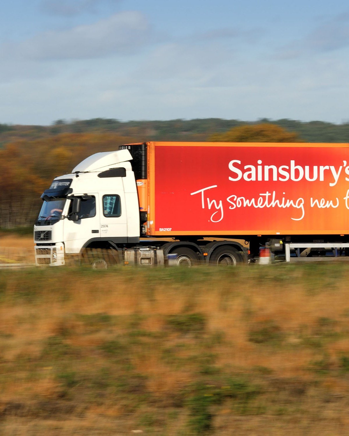 a row of orange delivery trucks parked next to each other