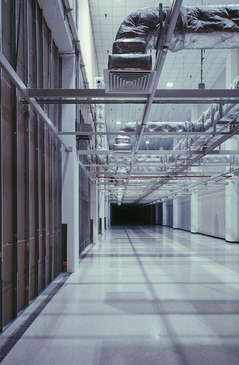 Long hallway with exposed pipes and ventilation systems